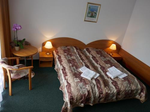 a bedroom with a large bed with a table and a chair at Dom Wypoczynkowy Passat in Niechorze