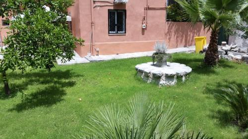 a garden with a small fountain in the grass at Vesuvius Gardens - Fagianeria Borbonica Relais in Ercolano