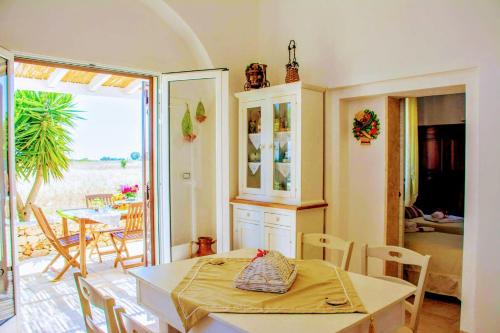een keuken en eetkamer met een tafel en stoelen bij Casale Conte Dell'Anna in Porto Cesareo