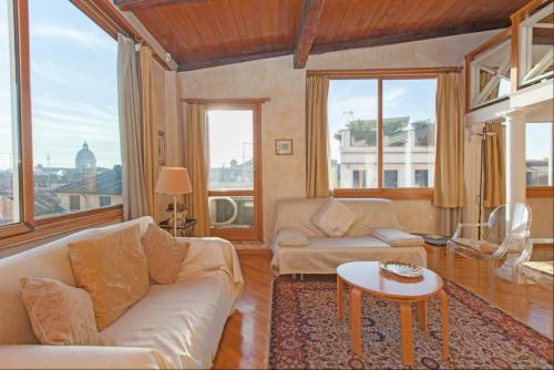 un soggiorno con divano e tavolo di Amazing panoramic artitst's loft Spanish Steps a Roma