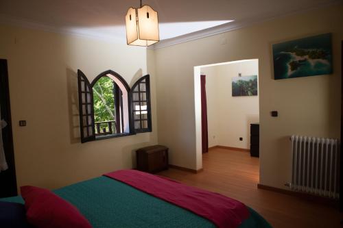 Casa da torre في بومبال: غرفة نوم بسرير ونافذة