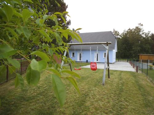 a swing in a yard in front of a house at Haus _Sonneneck_ 2 Fewo in Ostseebad Karlshagen