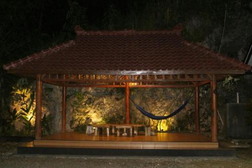um gazebo com um banco e uma mesa em Sederhana Homestay em Batukaras