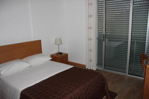 GinetesにあるA Casa Sousaのベッドルーム1室(ベッド1台、ブラインド付きの窓付)