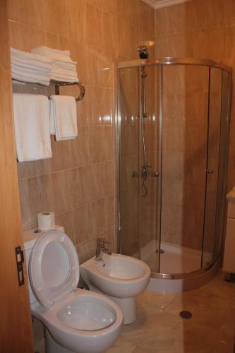 a bathroom with a shower and a toilet and a sink at A Casa Sousa in Ginetes