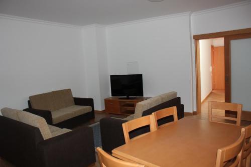 a living room with a table and chairs and a television at A Casa Sousa in Ginetes