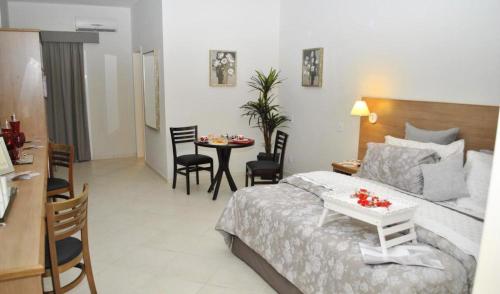 a hotel room with a bed and a table and chairs at Lazuli Hotel in Itatiba