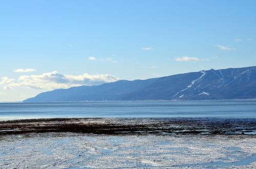 a large body of water with mountains in the background at Hotel-Motel Les Voitures d'Eau in L'Isle-aux-Coudres
