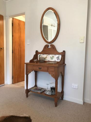 a wooden table with a mirror on a wall at McIvor Lodge in Invercargill