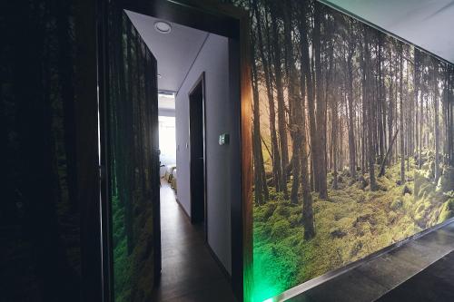 a hallway with a wall mural of a forest at Hotel Cruzeiro in Angra do Heroísmo