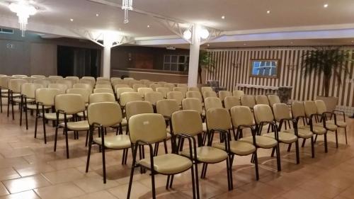 a room with a row of chairs in a hall at Villa Verde Hotel in Avaré