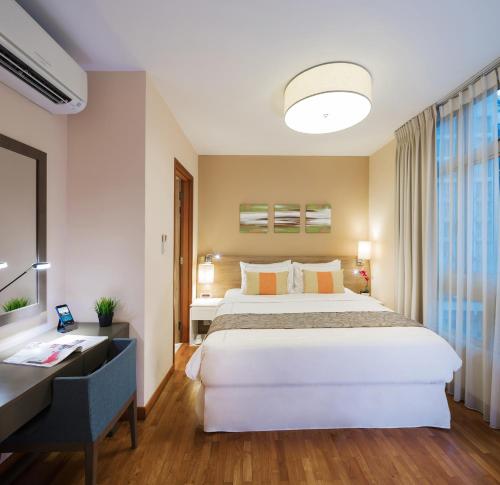 a hotel room with a large bed and a desk at Park Avenue Robertson in Singapore
