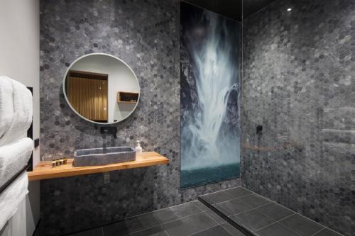 W łazience znajduje się umywalka i lustro. w obiekcie The Cinema Suites w mieście Te Anau