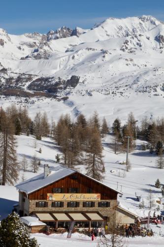 a building in the snow with a snow covered mountain at le Chal'heureux in Vars