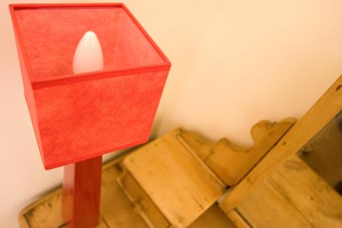 a red candle holder sitting on top of a table at A l'ombre du clocher in Calenzana