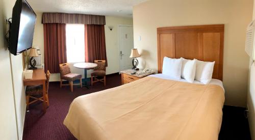 ハンツビルにあるハンツビル インのベッドとデスクが備わるホテルルームです。