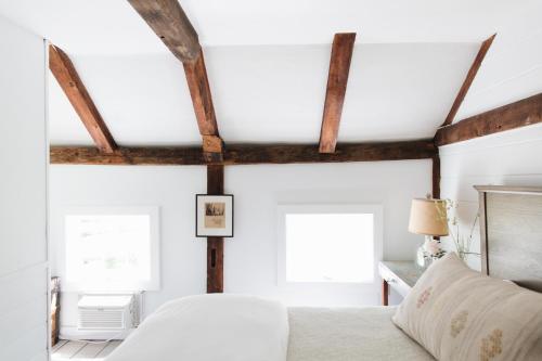 a bedroom with a white bed and wooden ceilings at Squire Tarbox Inn in Westport
