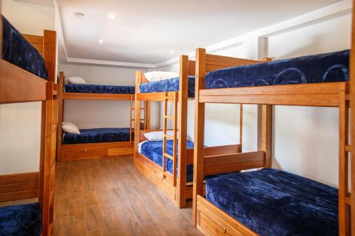 a room with four bunk beds in a house at Community Hostel Alausi in Alausí