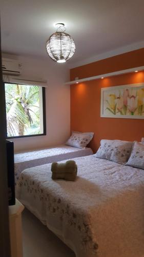 a bedroom with a bed with a stuffed animal on it at Ubatuba Apto. Wembley Tênis in Ubatuba