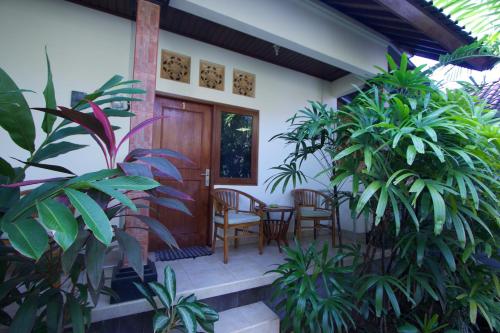 a front porch of a house with chairs and plants at Jepun Bali Homestay Sanur in Sanur