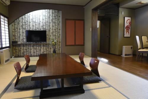 a dining room with a wooden table and chairs at Super Hydrogen Rich Spa Yado Kanzan in Minakami
