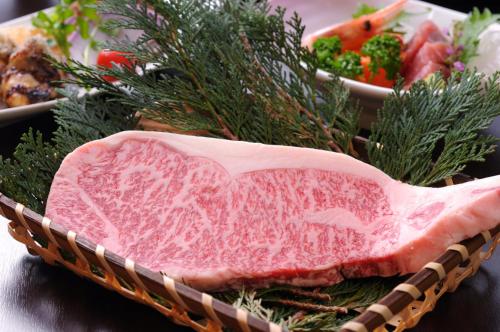 a piece of meat in a basket with vegetables at Super Hydrogen Rich Spa Yado Kanzan in Minakami