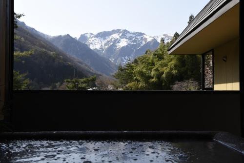 a room with a view of a mountain at Super Hydrogen Rich Spa Yado Kanzan in Minakami