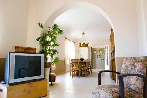 a living room with a tv on a wooden table at A l'ombre du clocher in Calenzana