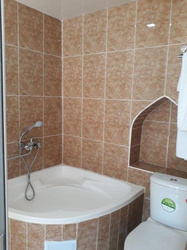a bathroom with a bath tub and a toilet at Caravan Sarai Yotoqxona in Khiva