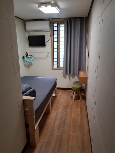 a small room with a bed and a window at Take 1 Guesthouse Hongdae in Seoul