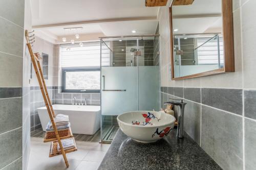 baño con bañera grande y lavamanos en The Bamboo Leaf Yangshuo, en Yangshuo