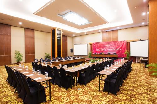 a large banquet hall with tables and chairs and a podium at Tara Hotel Yogyakarta in Yogyakarta