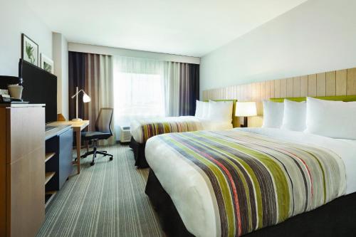 a hotel room with two beds and a desk at Country Inn & Suites by Radisson Ocean City in Ocean City