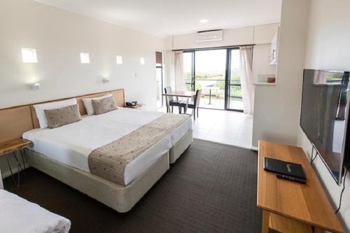 a hotel room with a large bed and a table at Margarets Beach Resort in Margaret River Town