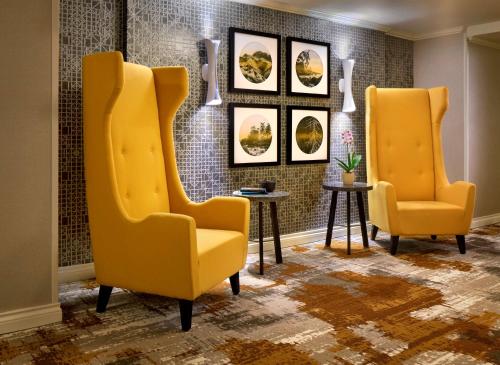 two yellow chairs and a table in a room at Hyatt Regency Vancouver in Vancouver