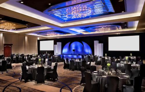 une salle de conférence avec des tables, des chaises et des écrans dans l'établissement Hyatt Regency Vancouver, à Vancouver