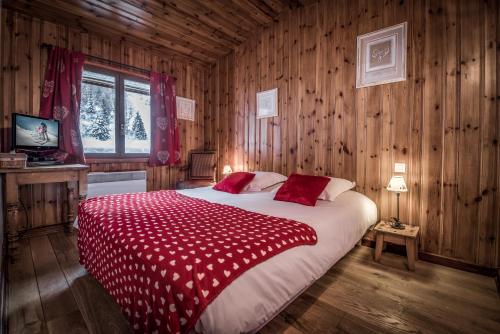 ein Schlafzimmer mit einem großen Bett mit einer roten Decke in der Unterkunft Chalet Du Friolin in Les Coches