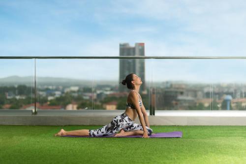 a woman doing a yoga pose on the grass at Brighton Grand Hotel Pattaya - SHA Extra Plus in North Pattaya