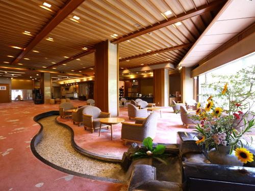 a lobby with chairs and tables in a building at Kamisuwa Onsen Aburaya Ryokan in Suwa