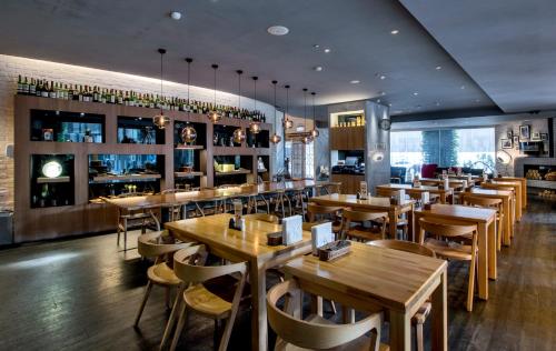 un restaurante con mesas y sillas de madera y un bar en The Carlton Hotel Hsinchu en Hsinchu City