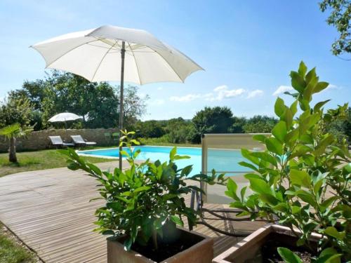 un patio avec un parasol et une piscine dans l'établissement Gites de charme en provence occitane, à Saint-André-dʼOlérargues