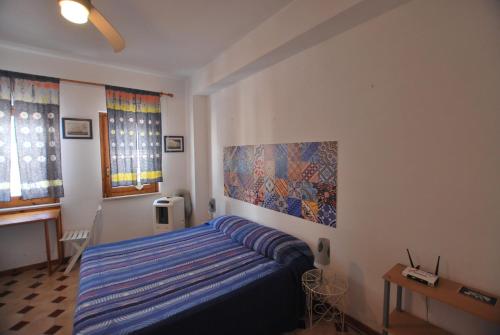 リーパリにあるLipari Monolocale centro storicoのベッドルーム1室(ベッド1台付)が備わります。壁には絵画が飾られています。