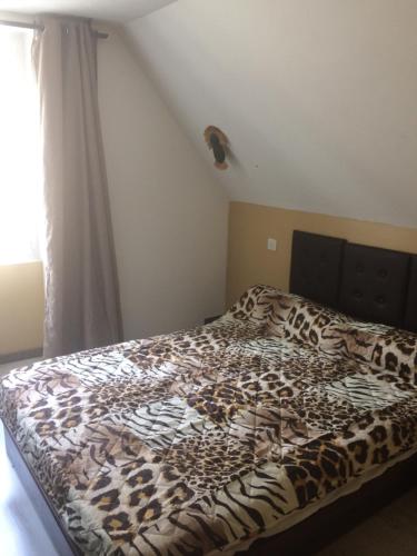 Una cama en un dormitorio con una manta de estampado de leopardo en Guitte family en Poilly-sur-Serein
