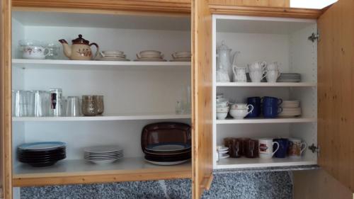 a cabinet filled with plates and cups and dishes at Apartment Kaprun in Niedernsill