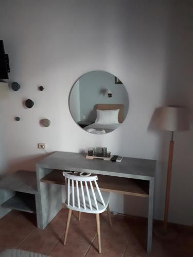 a desk with a mirror and a white chair at Loutro Holidays in Loutro