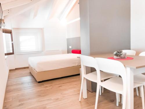 een slaapkamer met een bed en een tafel en stoelen bij Al Campanile di San Daniele in San Daniele del Friuli