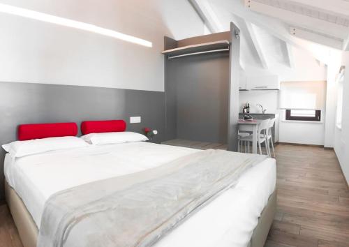 a bedroom with a large white bed with a red headboard at Al Campanile di San Daniele in San Daniele del Friuli