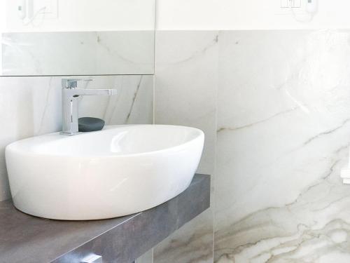a white sink in a bathroom with marble walls at Al Campanile di San Daniele in San Daniele del Friuli