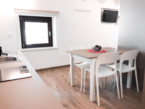 a white table and chairs in a kitchen with a sink at Al Campanile di San Daniele in San Daniele del Friuli