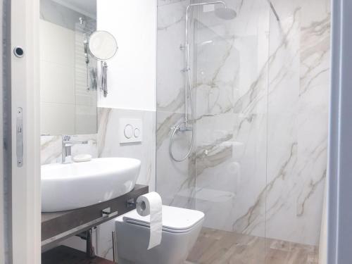 a bathroom with a sink and a toilet and a shower at Al Campanile di San Daniele in San Daniele del Friuli
